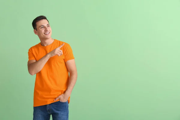 Bonito Jovem Camiseta Laranja Apontando Para Algo Fundo Cor — Fotografia de Stock