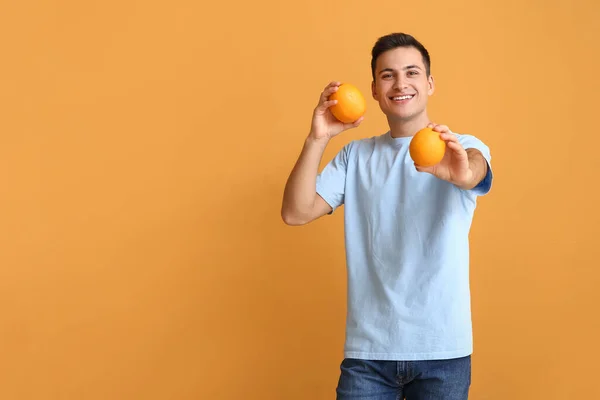 Knappe Man Met Rijpe Sinaasappels Kleur Achtergrond — Stockfoto