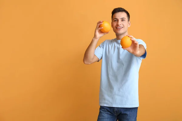 Knappe Man Met Rijpe Sinaasappels Kleur Achtergrond — Stockfoto