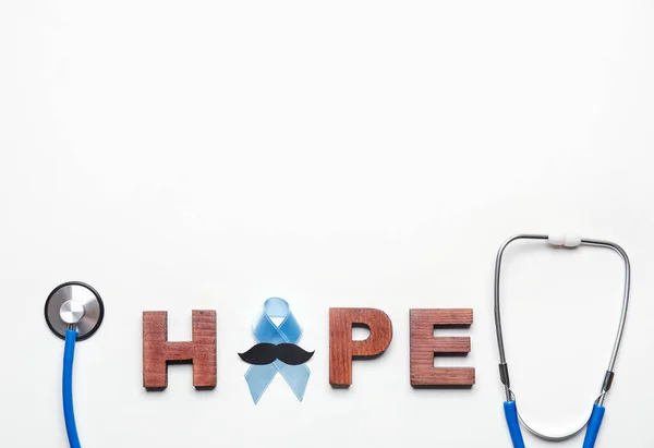 Word HOPE, blue ribbon, mustache and stethoscope on white background. Prostate cancer awareness concept