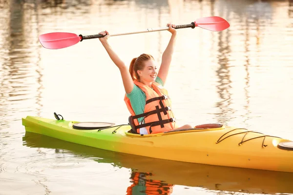 Young woman kayaking in river