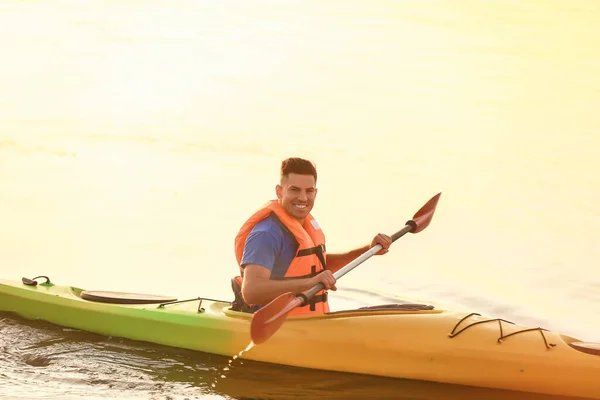 Young man kayaking in river