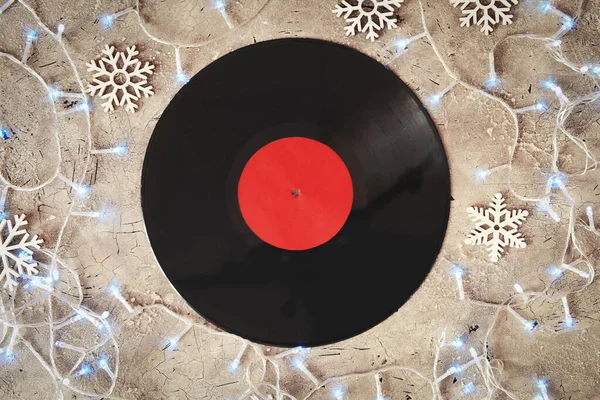 Vinyl disk and Christmas decor on grey background
