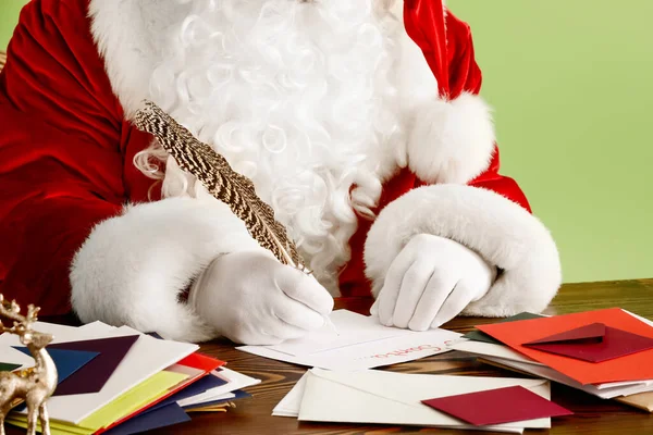 Санта Клаус Составляет Список Подарков Цветном Фоне — стоковое фото