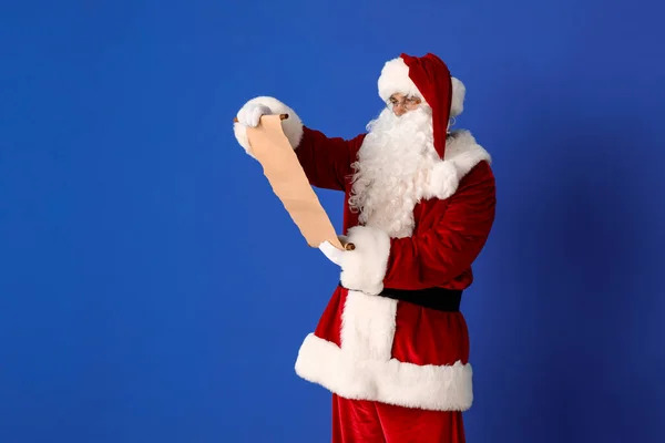 Weihnachtsmann Liest Brief Auf Farbigem Hintergrund — Stockfoto