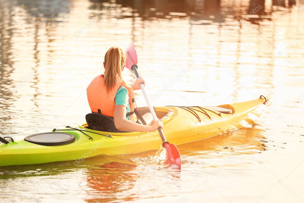 Young woman kayaking in river