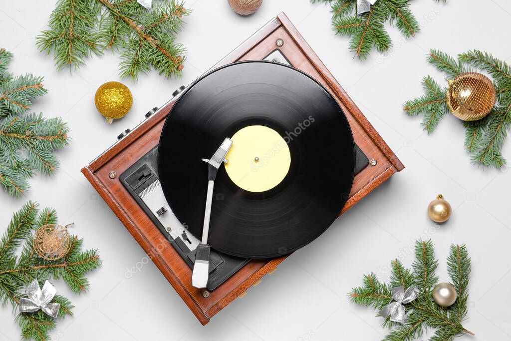 Record player and Christmas decor on light background