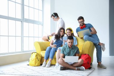 Modern cihazları olan öğrenciler çevrimiçi olarak kapalı alanda çalışıyorlar.