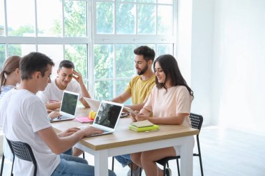 Modern cihazları olan öğrenciler çevrimiçi olarak kapalı alanda çalışıyorlar.