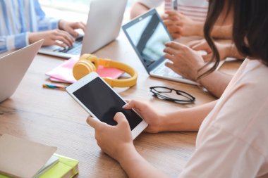 Modern cihazları olan öğrenciler çevrimiçi olarak kapalı alanda çalışıyorlar.