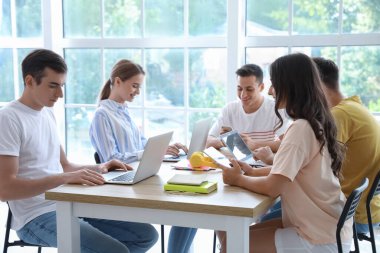 Modern cihazları olan öğrenciler çevrimiçi olarak kapalı alanda çalışıyorlar.