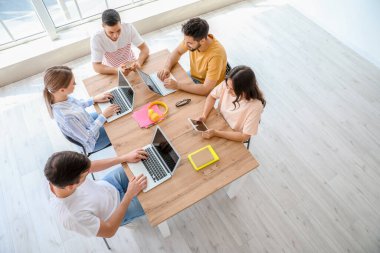 Modern cihazları olan öğrenciler çevrimiçi olarak kapalı alanda çalışıyorlar.