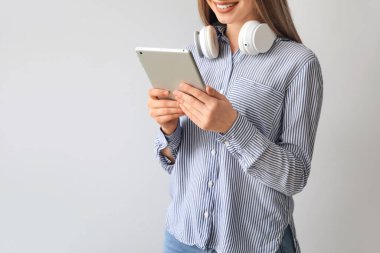 Açık arkaplanda tablet bilgisayarı olan kız öğrenci