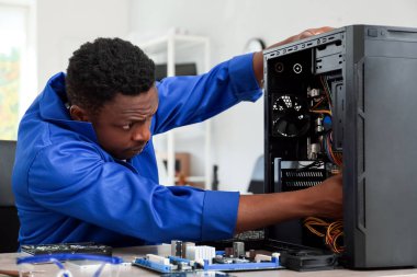 Servis merkezinde bilgisayar tamir eden Afro-Amerikalı teknisyen