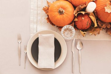 Yemek odasında balkabakları ve sonbahar yaprakları olan güzel bir masa.