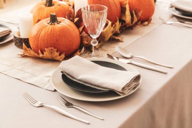 Yemek odasında balkabakları ve sonbahar yaprakları olan güzel bir masa.