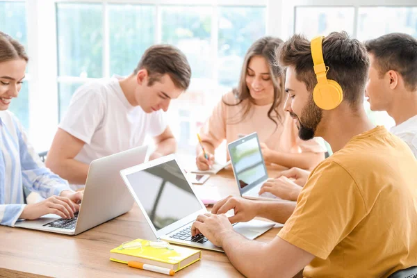 Students with modern devices studying online indoors