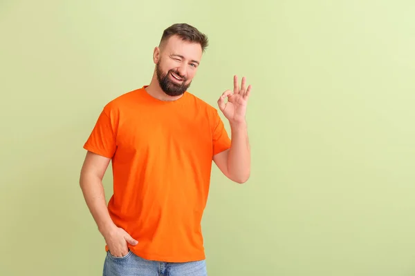 Jóképű Férfi Narancssárga Pólóban Mutatja Színes Háttér — Stock Fotó