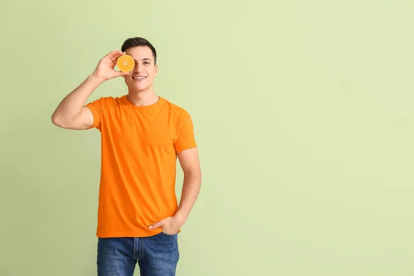 Hombre Guapo Con Naranja Madura Sobre Fondo Color — Foto de Stock