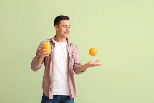 ハンサムな男とともにオレンジジュースオンカラー背景 — ストック写真