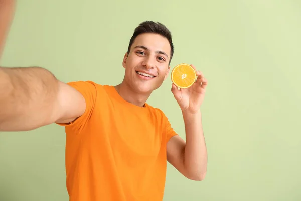 Bonito Homem Com Laranja Madura Tirando Selfie Fundo Cor — Fotografia de Stock