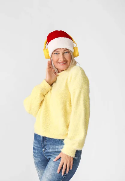 Gri Arka Planda Noel Müziği Dinleyen Olgun Bir Kadın — Stok fotoğraf