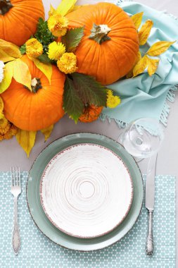 Yemek odasında balkabakları ve sonbahar yaprakları olan güzel bir masa.