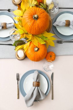 Yemek odasında balkabakları ve sonbahar yaprakları olan güzel bir masa.