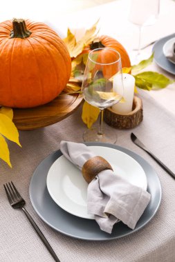 Yemek odasında balkabakları ve sonbahar yaprakları olan güzel bir masa.