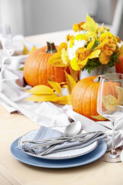 Yemek odasında balkabakları ve sonbahar yaprakları olan güzel bir masa.