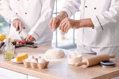 Aşçılar mutfakta lezzetli yemekler pişiriyor.