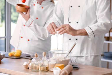 Aşçılar mutfakta lezzetli yemekler pişiriyor.