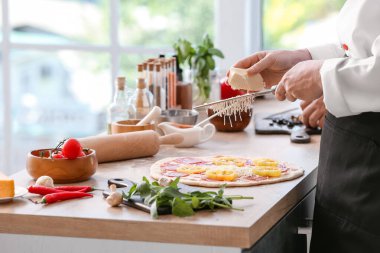 Şef mutfakta lezzetli pizza yapıyor.