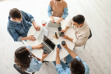 Modern cihazları olan öğrenciler çevrimiçi olarak kapalı alanda çalışıyorlar.