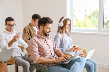 Modern cihazları olan öğrenciler çevrimiçi olarak kapalı alanda çalışıyorlar.