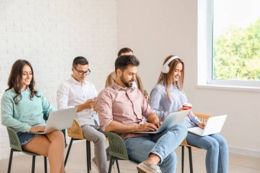 Modern cihazları olan öğrenciler çevrimiçi olarak kapalı alanda çalışıyorlar.