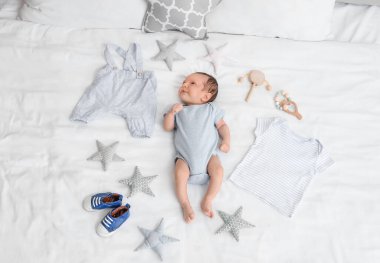 Giysileri ve aksesuarları olan küçük şirin bir bebek.