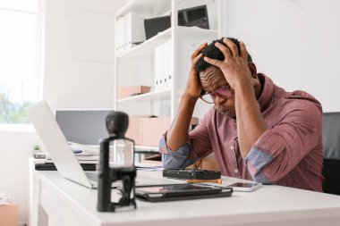 Stresli teknisyen servis merkezinde bilgisayar tamir ediyor