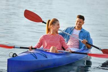 Genç çift nehirde kayak yapıyor.