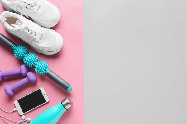 Körperrolle Mit Schuhen Hanteln Wasserflasche Und Handy Auf Farbigem Hintergrund — Stockfoto