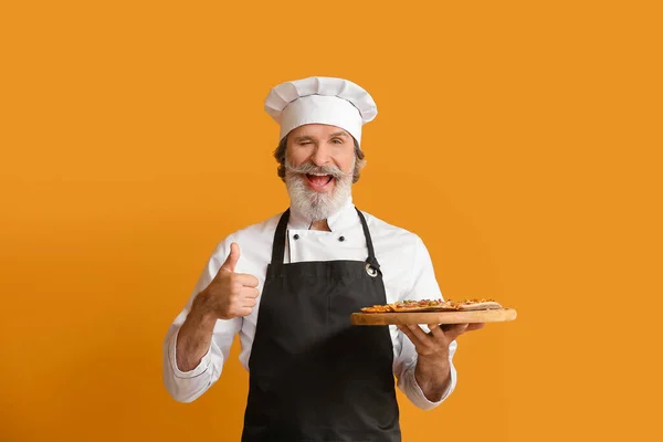 Chef Macho Maduro Con Sabrosa Pizza Sobre Fondo Color —  Fotos de Stock