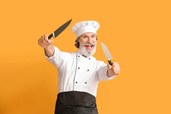 Ältere Männliche Koch Mit Messern Auf Farbhintergrund — Stockfoto