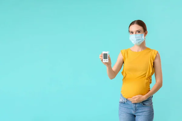 戴医疗面罩的糖尿病孕妇及彩色背景的数码糖蜜计 — 图库照片