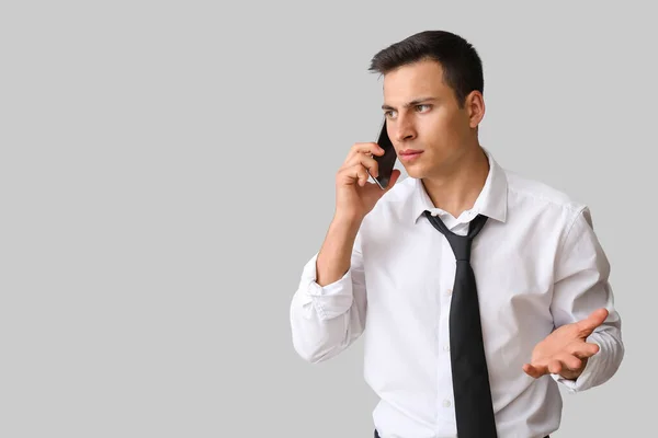 Zestresowany Młody Biznesmen Rozmawiający Przez Telefon Lekkim Tle — Zdjęcie stockowe
