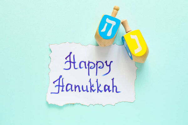 Dreidels for Hanukkah on color background