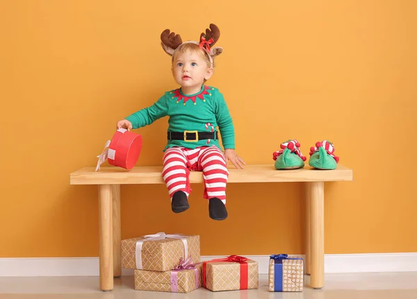 Niedliches Kleines Baby Elfenkostüm Und Mit Weihnachtsgeschenk Auf Bank Neben — Stockfoto