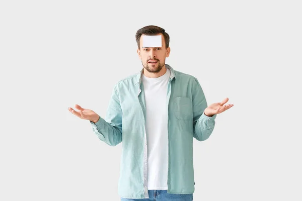 Confused Man Blank Note Paper His Forehead Grey Background — Stock Photo, Image