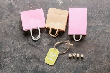 Alışveriş torbaları ve etiketler ile metin CYBER Pazartesi Gri arka planda satış