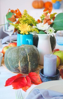 Yemek odasında balkabakları ve sonbahar yaprakları olan güzel bir masa.