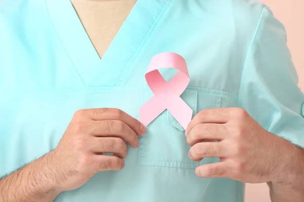 Arzt Mit Rosa Schleife Auf Farbigem Hintergrund Nahaufnahme Brustkrebs Aufklärungskonzept — Stockfoto